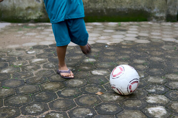 child playing soccer on street
