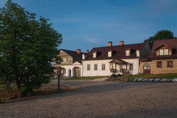 View of historical merchant buildings of estates on the main street of Izborsk Pechorskaya Street on a summer sunny day, Izborsk, Pskov region, Russia