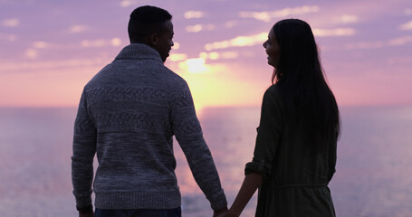 Sunset, beach and couple holding hands on holiday date, romantic adventure or sightseeing from...