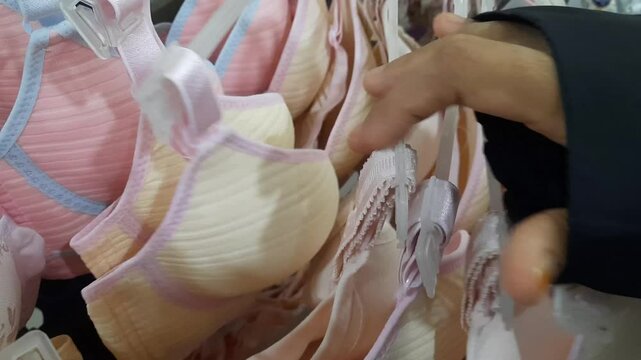 Woman choosing bra in underwear boutique, closeup