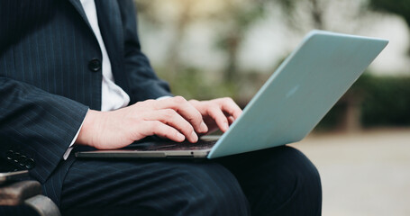 Laptop, businessman and hands typing at park for remote work, research or environmental consultant writing email. Employee, online and computer in city closeup for sustainable project review in Japan