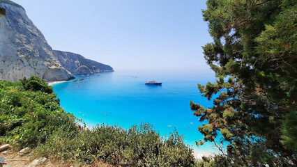 Fototapeta premium A boat is floating on the clear blue water with a blue sky