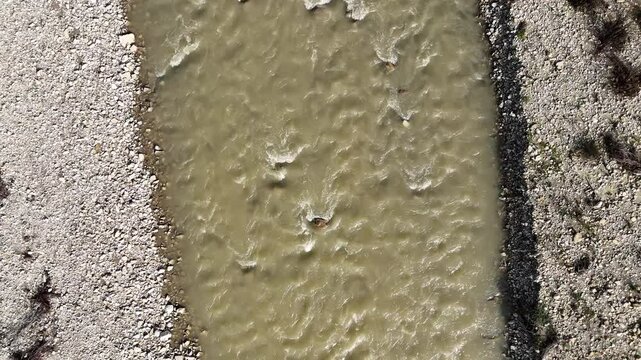 Arda River in Val Tolla Lugagnano, Piacenza, italy Muddy in riverbed flowing between rocky riverbanks in the italian countryside, Mignano, Lugagnano D'Arda, Piacenza, Italy, overhead shot
