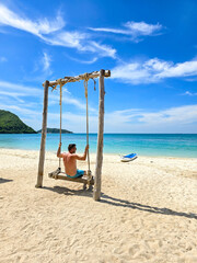 Relaxing on a swing at Samae San Island in Thailand under the vibrant blue sky