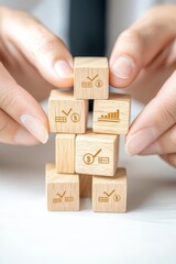Close-up of hands arranging wooden blocks with financial terms on them, building business foundations