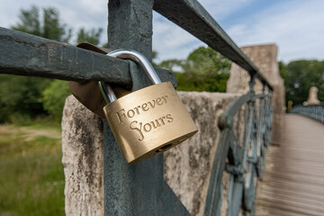 Engraved lock on a love bridge symbolizing eternal commitment
