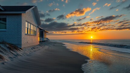 beachside retreat with pale brick siding, reflecting the glow of a sunset over the ocean