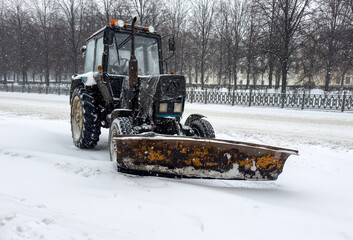 A tractor is plowing snow in a field
