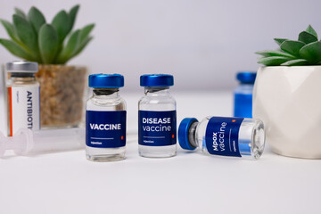 some vaccines with artificial flowers on a table inside a medical clinic. health and medical concepts