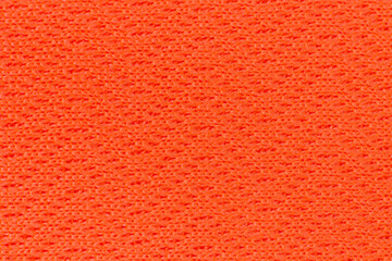 A close-up of a vibrant orange fabric with a textured weave. The material has a soft, slightly fuzzy appearance and a smooth, even surface, perfect for athletic wear 