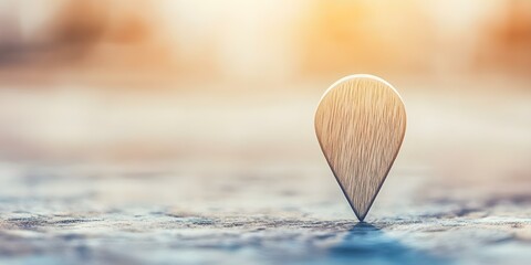 A wooden location pin standing upright on a blurred background, symbolizing navigation or a specific point on a map. Concept Wooden Location Pin, Navigation Symbol, Map Marker, Blurred Background