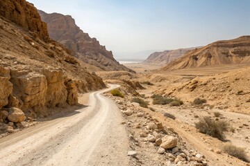 Desert dirt road cutting through a rocky canyon in the desert near the Dead Sea, winding path, desert scenery, geological formations, dirt road, stone formations