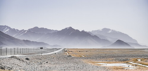 Asphalt road of the Pamir Highway in the valley of the Tien Shan Mountains in Tajikistan in the...