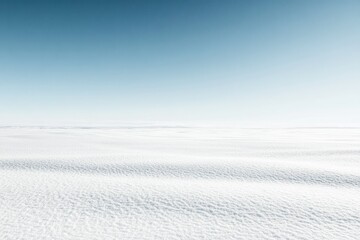A serene snowy landscape under a clear blue sky, evoking tranquility and vastness.