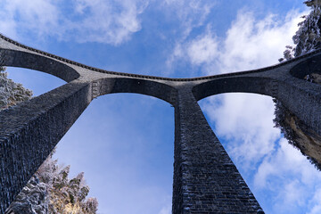 Looking up to famous Landwasser Viaduct in the Swiss Alps at mountain village of Filisur on an...