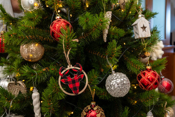 A Christmas tree with many ornaments, including a bull ornament. The tree is lit up and he is a festive decoration