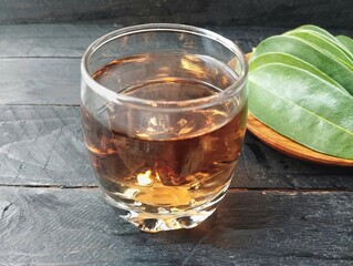 Soursop leaf boiled water in glass on wooden table. Has many health benefits 