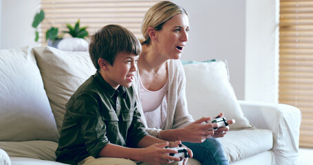 Playing, mom and son in living room, video game and bonding with tech, fun and competitive in house. Lounge, gamer and woman with console, kid and subscription for happy family, electronics and home © peopleimages.com
