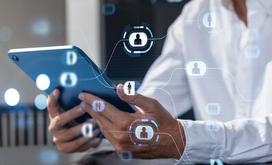 Hands holding a tablet with holographic human icons for network connections on a blurred background.