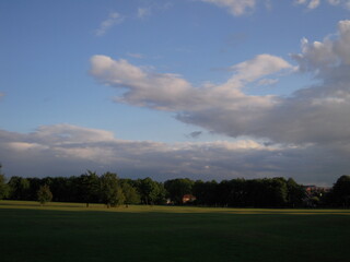 On the vast grassland, there is a gentle breeze, low clouds, green grass, and the distant horizon meets the sky. The scenery is peaceful and magnificent.