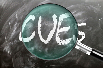 Cues - learn, study and inspect it. Taking a closer look at cues. A magnifying glass enlarging word 'cues' written on a blackboard ,3d illustration
