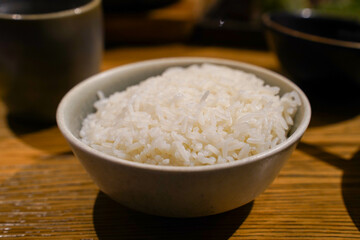 cooked rice cooked in a bowl on wooden table in restaurant.