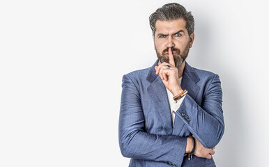 Handsome man asking for silence, quiet, gesturing with finger in front of mouth, saying shh or...