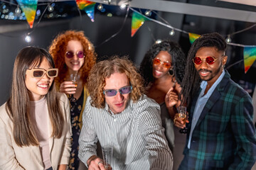 Diverse friends taking selfie in a night party at terrace