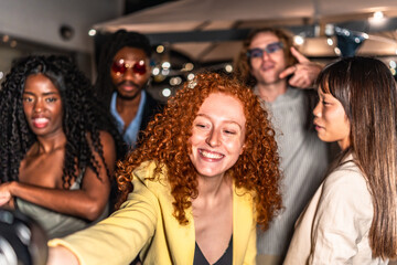 Happy friends taking selfie in a terrace during night party
