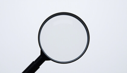 The image displays a magnifying glass with a round, clear lens and a black handle. It is positioned against a neutral background. There are no texts or additional objects visible in the image.