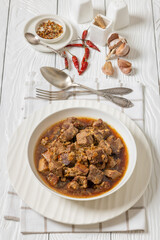 beer braised pork stew in a white bowl