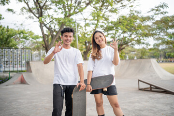 Obraz premium Two friends enjoy skateboarding in a sunny park, surrounded by trees and summer vibes