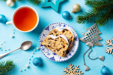 Christmas stollen. Traditional German festive dessert with cup of tea. Blue background. Top view.