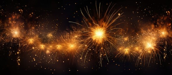 Fototapeta premium Festive golden sparkler fireworks illuminating a dark backdrop creating a vibrant celebration atmosphere with sparkling light effects.