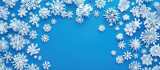 Winter backdrop featuring paper snowflakes on a vibrant blue background ideal for seasonal greeting cards or festive designs.