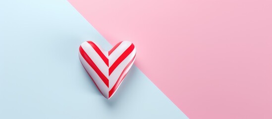 Vibrant heart-shaped candy cane on a pastel background showcasing a minimalistic and festive design perfect for holiday themes