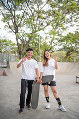 Two energetic skateboarders are having a great time enjoying their day at the skate park