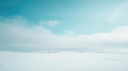 Teal blue sky with soft clouds transitioning to a white winter landscape featuring a bright atmosphere and a vivid cyan horizon during spring.