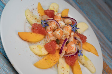 RECIPE CEVICHE OF SHRIMPS AND SCALLOPS WITH CITRUS FRUIT, LEMON, LIME, SQUEEZED ORANGE, GRAPEFRUIT AND FRUIT, PERSIMMON, APPLE, SEASONED WITH ESPELETTE PEPPER. High quality photo