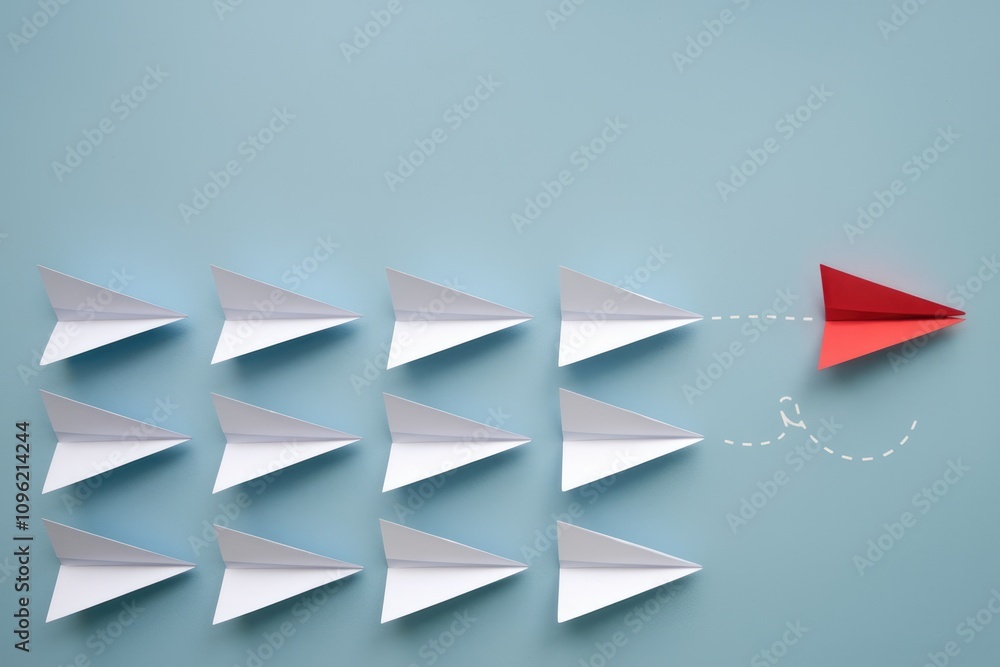 Aufkleber red paper airplane taking a different path than white ones