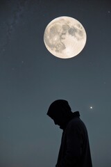 Fototapeta premium A figure contemplates under a glowing moon.