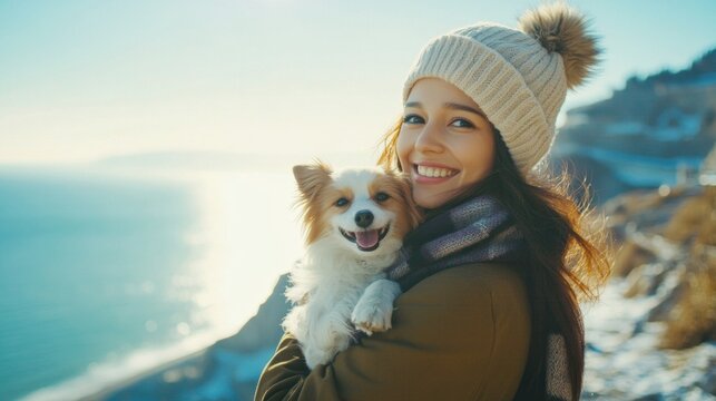 A woman is holding a white dog and smiling