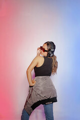 rear view of young Asian dancer woman wearing headphones and glasses