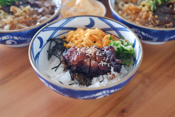 Each bowl contains different ingredients such as meats, vegetables, and rice, garnished with green herbs