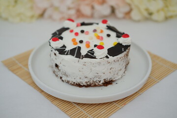 Cake with cherry on top on a bamboo mat 