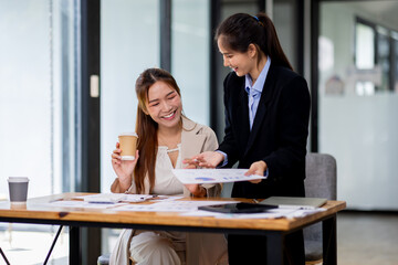 Two asian business women Accounting using calculating income-expenditure and analyzing real estate investment documents data report Financial and tax systems concept.
