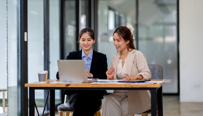 Two asian business women Accounting using calculating income-expenditure and analyzing real estate investment documents data report Financial and tax systems concept.