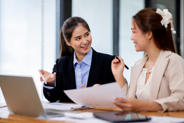 Fototapeta premium Two asian business women Accounting using calculating income-expenditure and analyzing real estate investment documents data report Financial and tax systems concept.