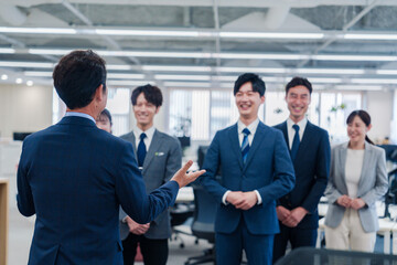オフィスで朝会をするビジネスパーソン