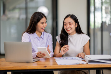 Financial Business two women analyze the graph of the company's performance to create profits and growth, Market research reports and income statistics, Financial and Accounting concept.	